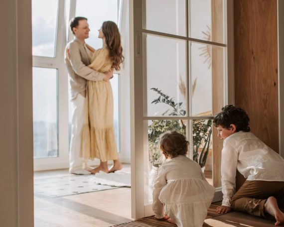 A joyful family moment indoors with parents and children enjoying a cozy home environment.