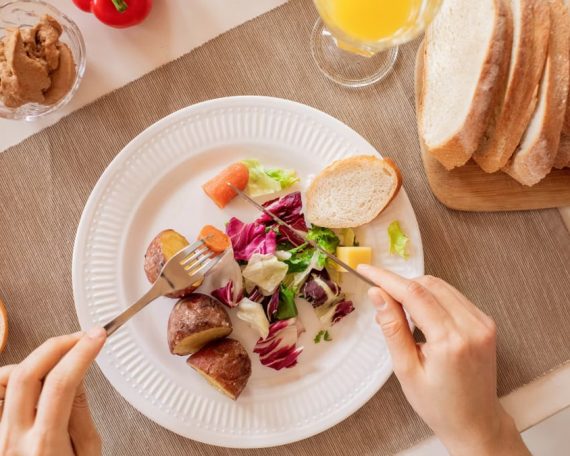 Top view of a nutritious breakfast setup with salad, bread, and fresh juice, perfect for a healthy start.